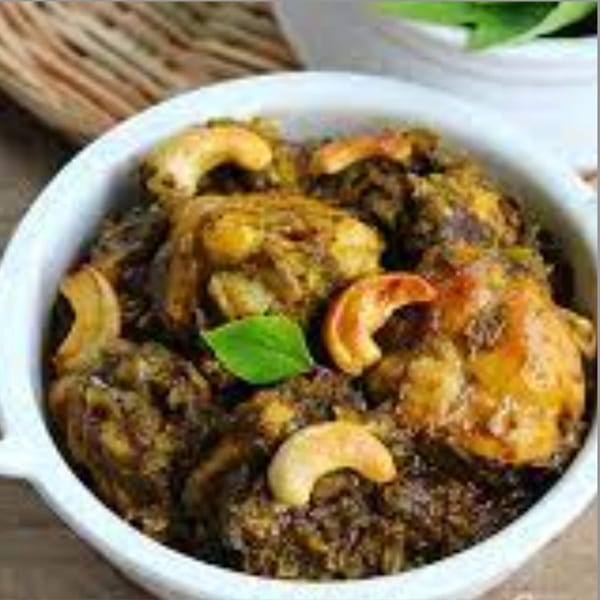 Kaveri South Indian Restaurant's chicken curry with cashews and a green herb garnish.